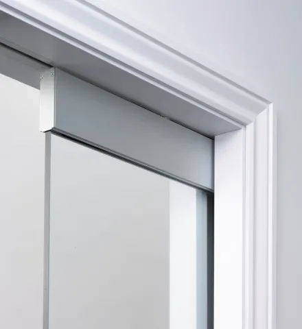 Frameless glass door in architrave clad pocket door kit
